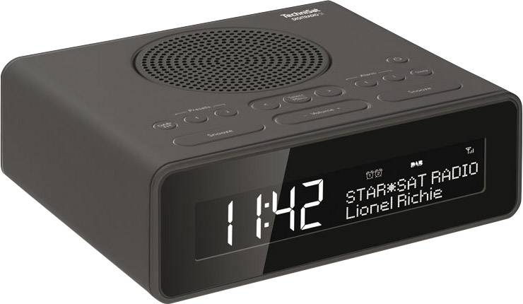 Ein schwarzer Digitalwecker zeigt 11:42 Uhr. Der Bildschirm zeigt 'STAR*SAT RADIO' und 'Lionel Richie'. Oben Knöpfe für Einstellungen.