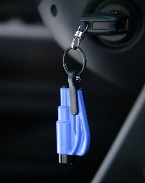 Ein blauer Sicherheitshammer hängt an einem Autoschlüssel im Zündschloss eines Fahrzeugs.