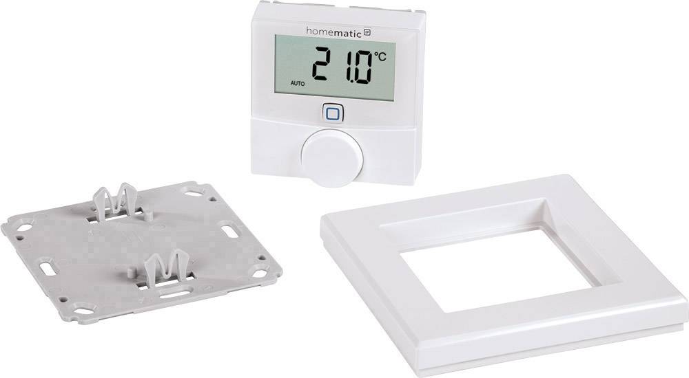 Ein elektronisches Thermostat mit Display zeigt '21.0°C'. Eine Metallplatte zur Montage und ein weißer Rahmen liegen daneben.