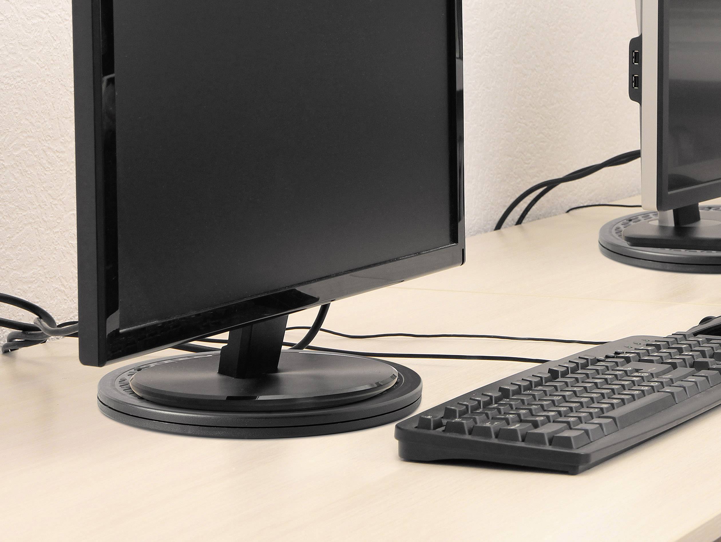 Ein Computermonitor und eine Tastatur stehen auf einem Schreibtisch in einem Büro. Kabel verlaufen hinter dem Monitor.