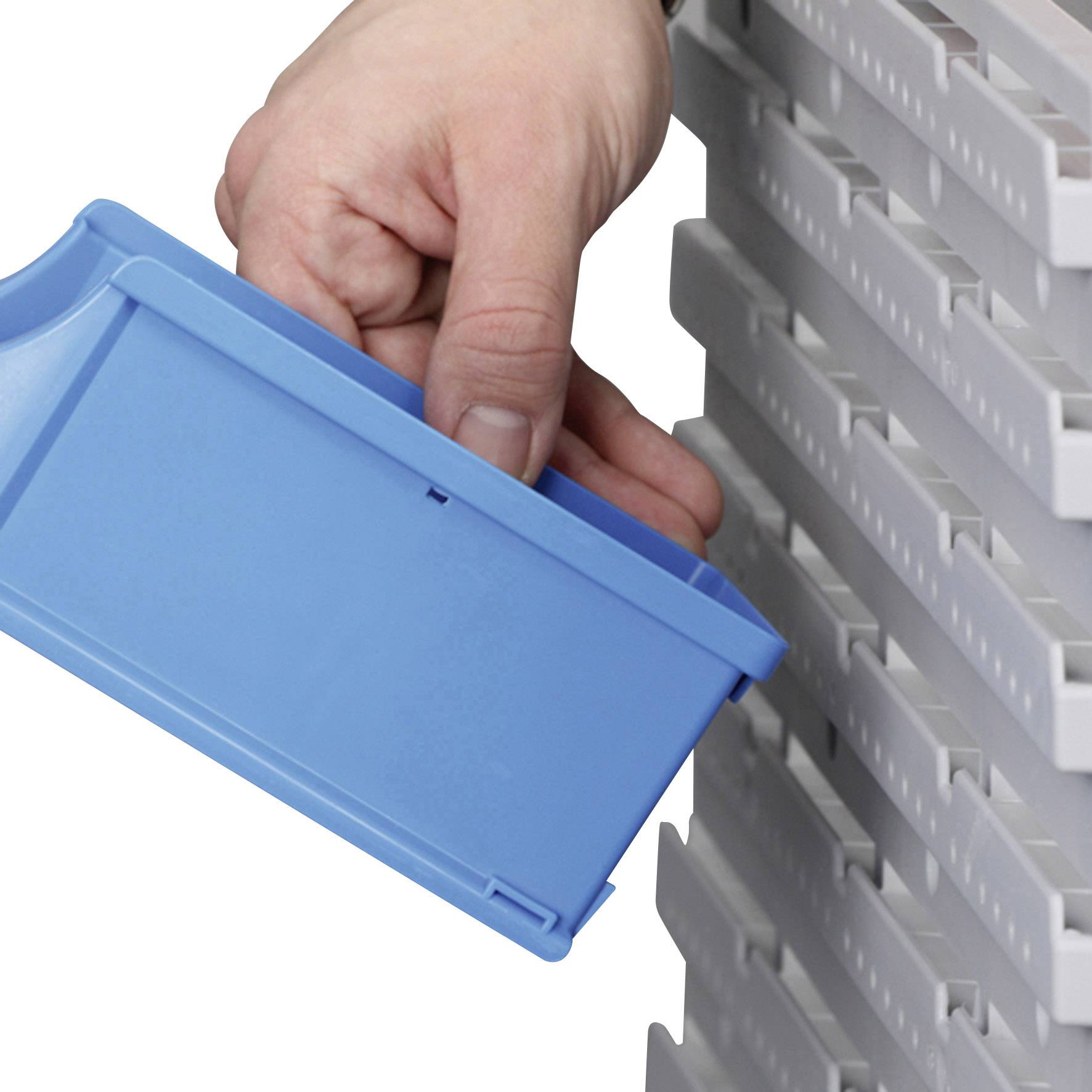 Eine Hand zieht eine blaue Plastikbox aus einem weißen Regal.