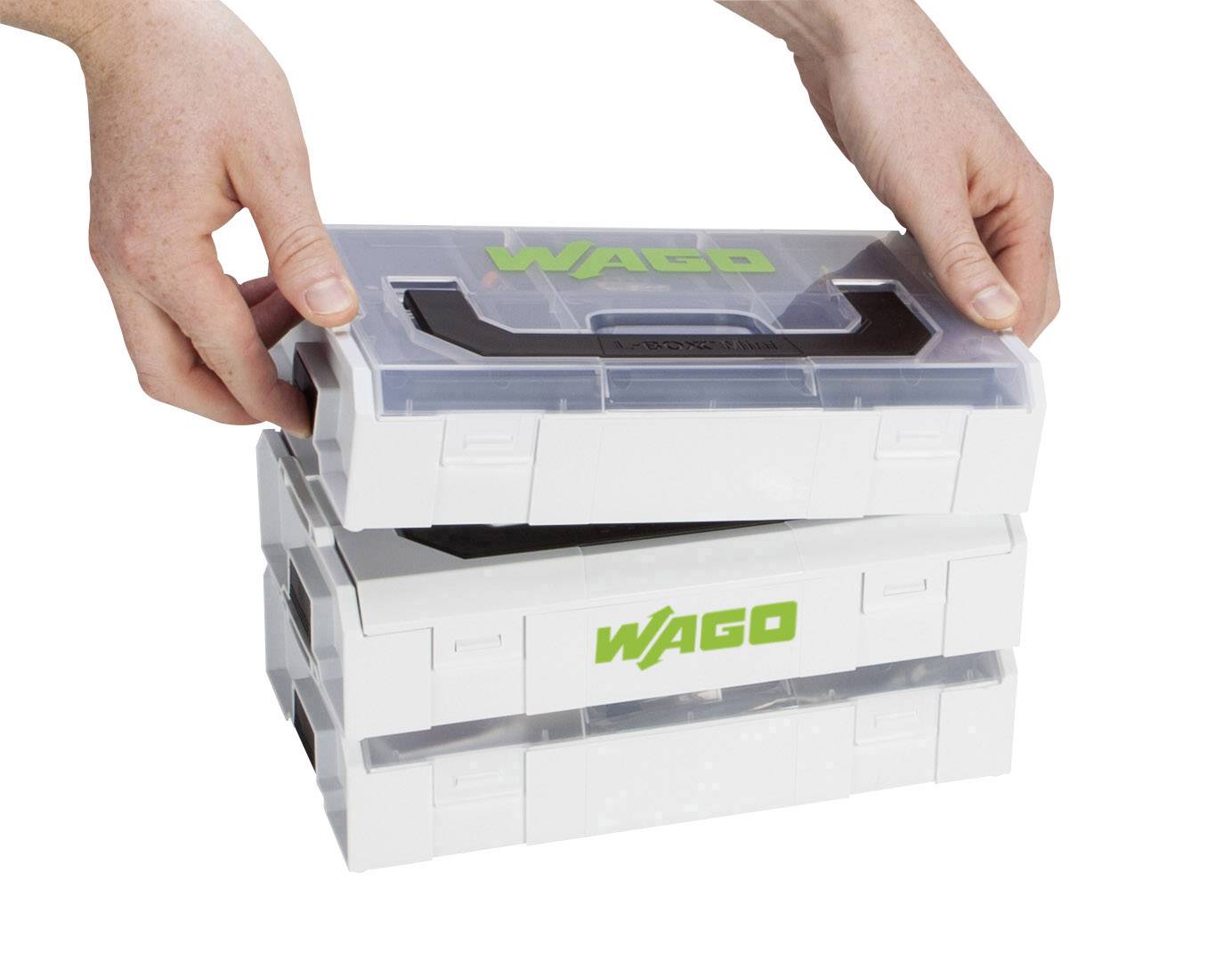 Zwei Hände stapeln drei weiße Kunststoffboxen mit dem grünen Logo 'WAGO' aufeinander.