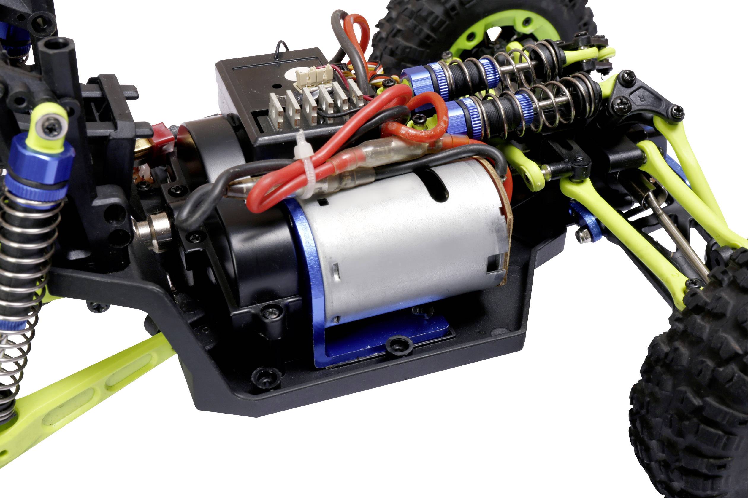 Nahaufnahme eines ferngesteuerten Autos mit sichtbarem Motor und Federungskomponenten.