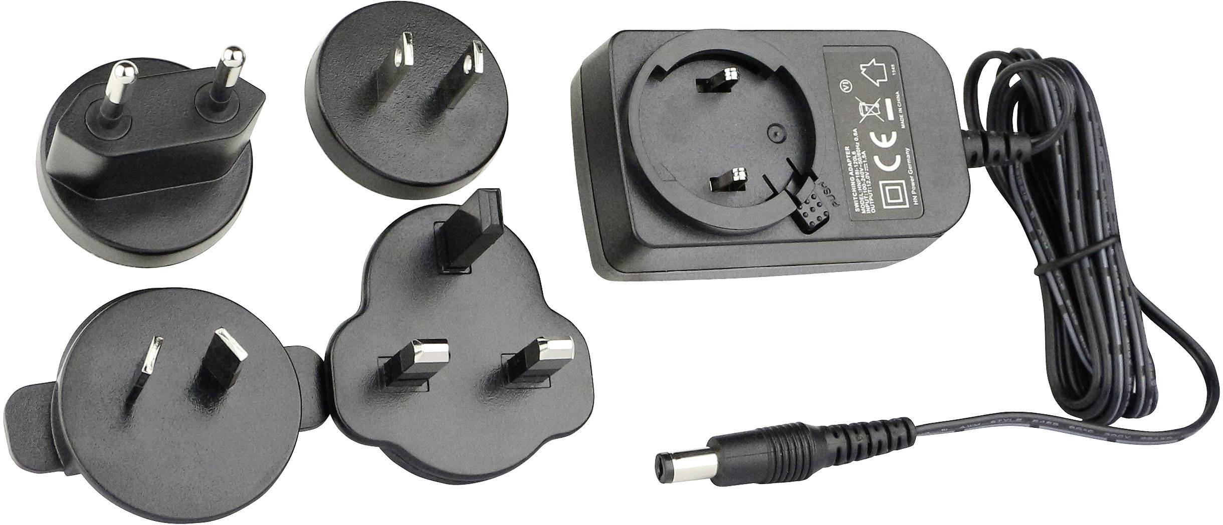 Verschiedene austauschbare Steckdosenadapter und ein Netzteil mit Kabel, geeignet für den internationalen Einsatz.
