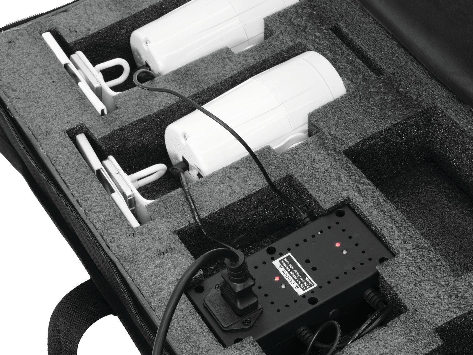 Schwarzer Koffer enthält zwei weiße Geräte und einen elektrischen Adapter mit Kabeln. Geräte liegen in passgenauen Aussparungen.