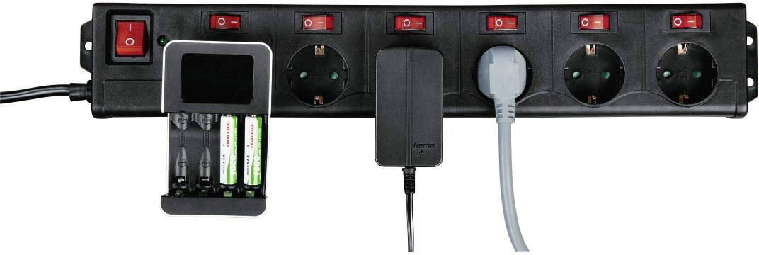 Schwarze Steckdosenleiste mit sechs Schaltern. Zwei Stecker sind eingesteckt, eins mit schwarzem Kabel, das andere mit grauem Kabel. Batterie-Ladegerät mit vier Batterien links daneben.