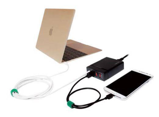 Ein Laptop ist über ein Kabel mit einem Ladegerät verbunden, an dem ein Smartphone angeschlossen ist.