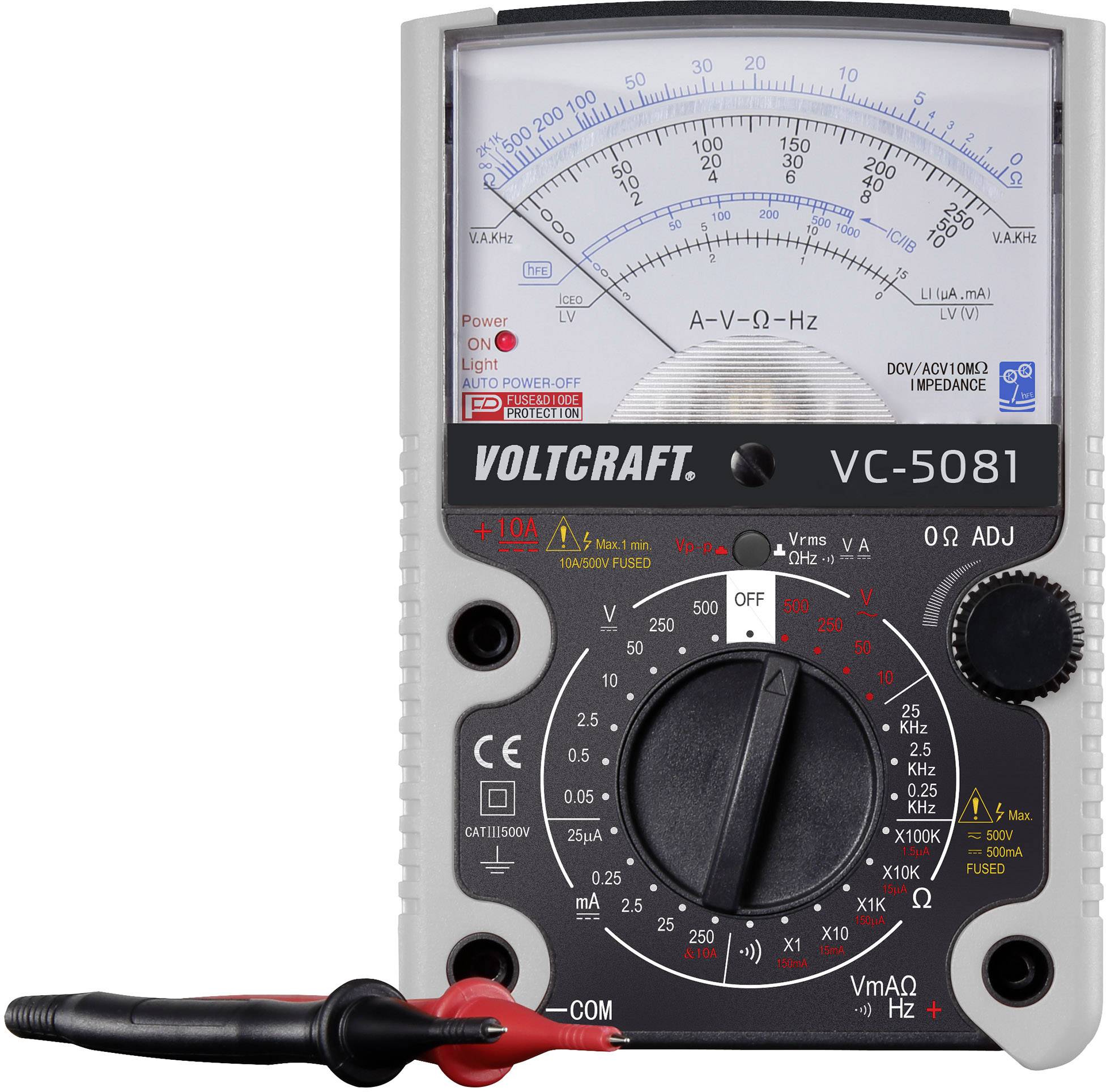 Analoges Multimeter 'Voltcraft VC-5081' zeigt Spannung, Widerstand und Frequenz auf Skala an. Zifferblatt und rote Messleitungen sichtbar.