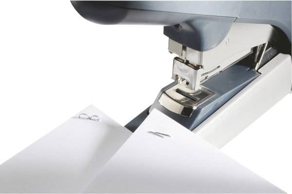 Ein Heftgerät drückt Klammern in zwei übereinanderliegende Papierblätter.