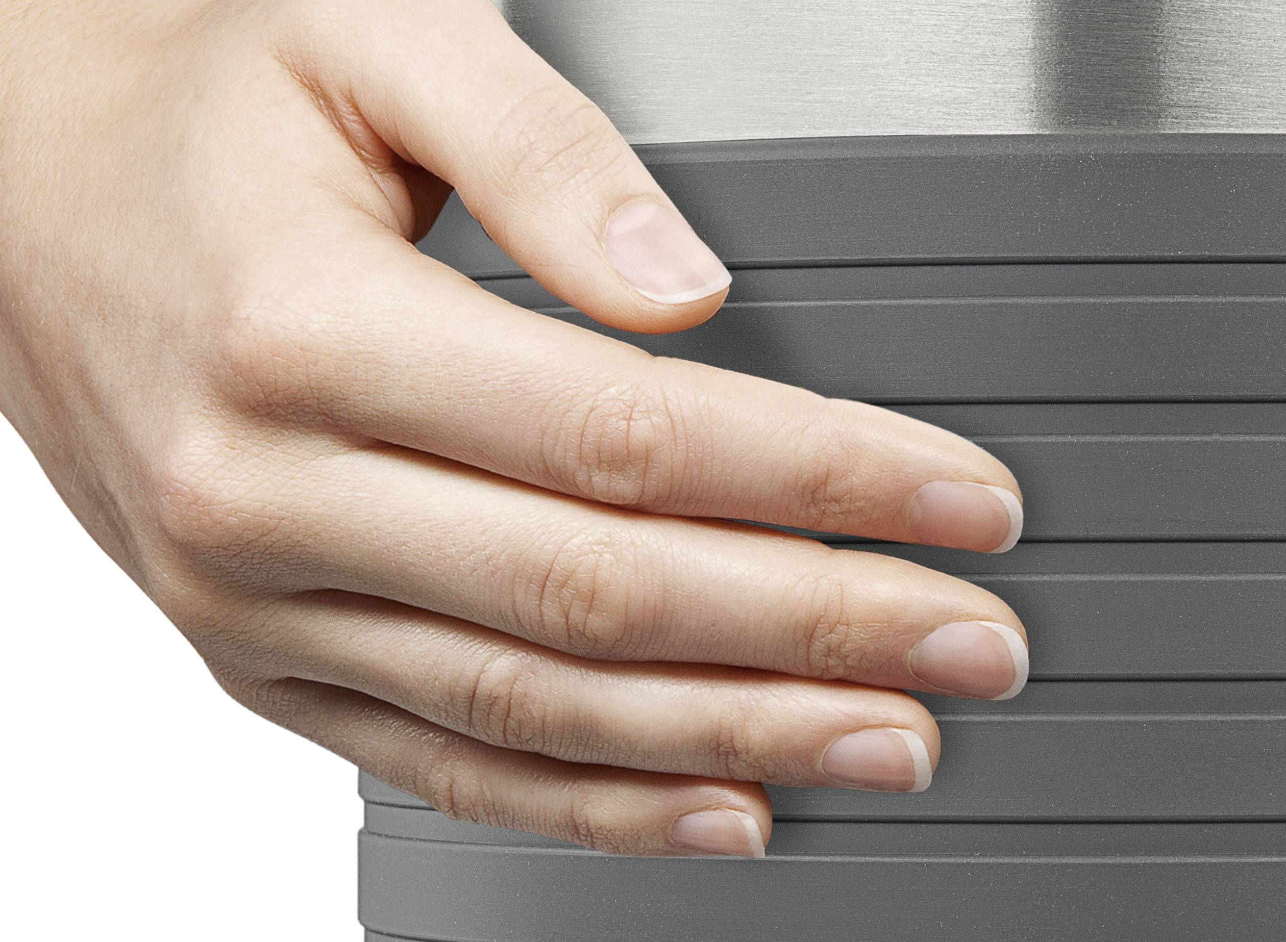 Eine Hand hält einen grauen, gerillten Becher. Die Hand ist entspannt um den Becher gelegt, was auf Komfort oder Halt hinweist.