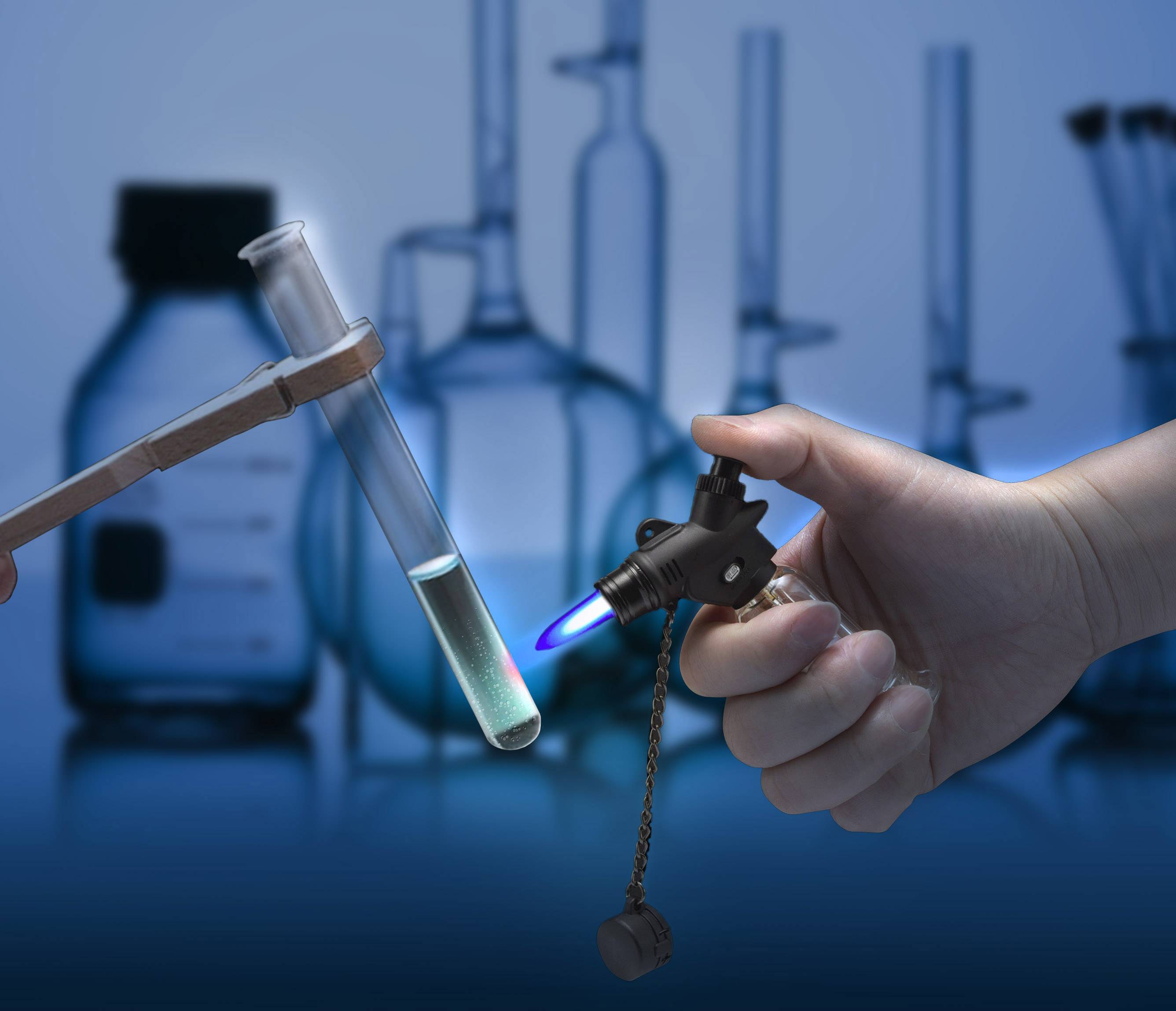 Hand hält einen Brenner, der ein Reagenzglas mit Flüssigkeit erhitzt. Hintergrund zeigt unscharfe Laborflaschen und Reagenzgläser.