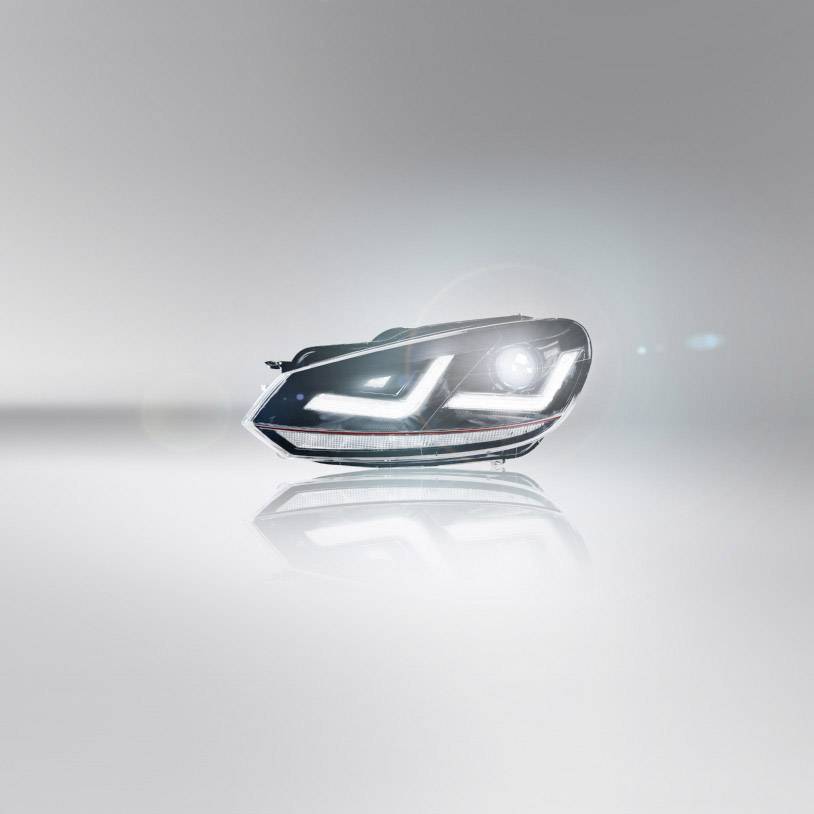 Ein modernes Autoscheinwerferdesign mit LED-Leuchten, auf einem hellen, reflektierenden Hintergrund.