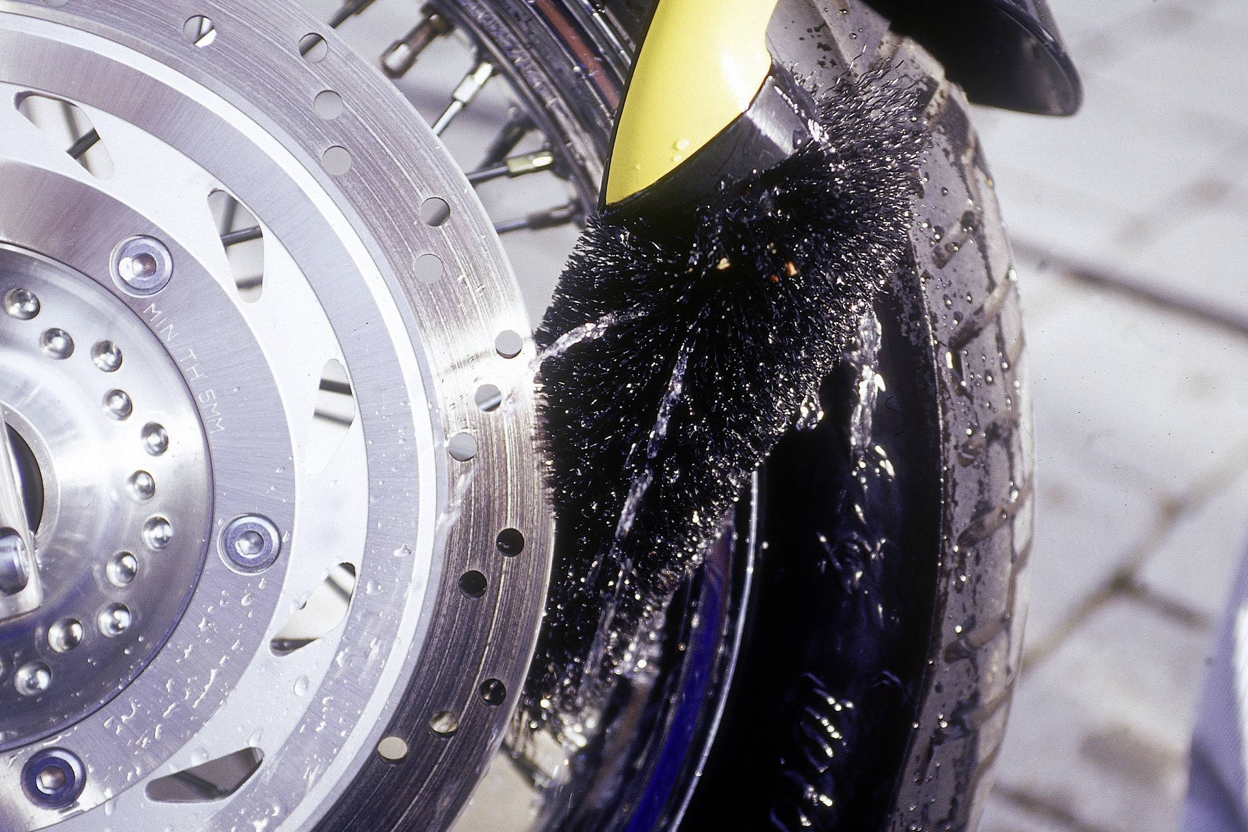 Ein Reifenspritzschutz an einem Motorradreifen, der Wasser abweist, um Spritzer auf nassen Straßen zu verhindern.