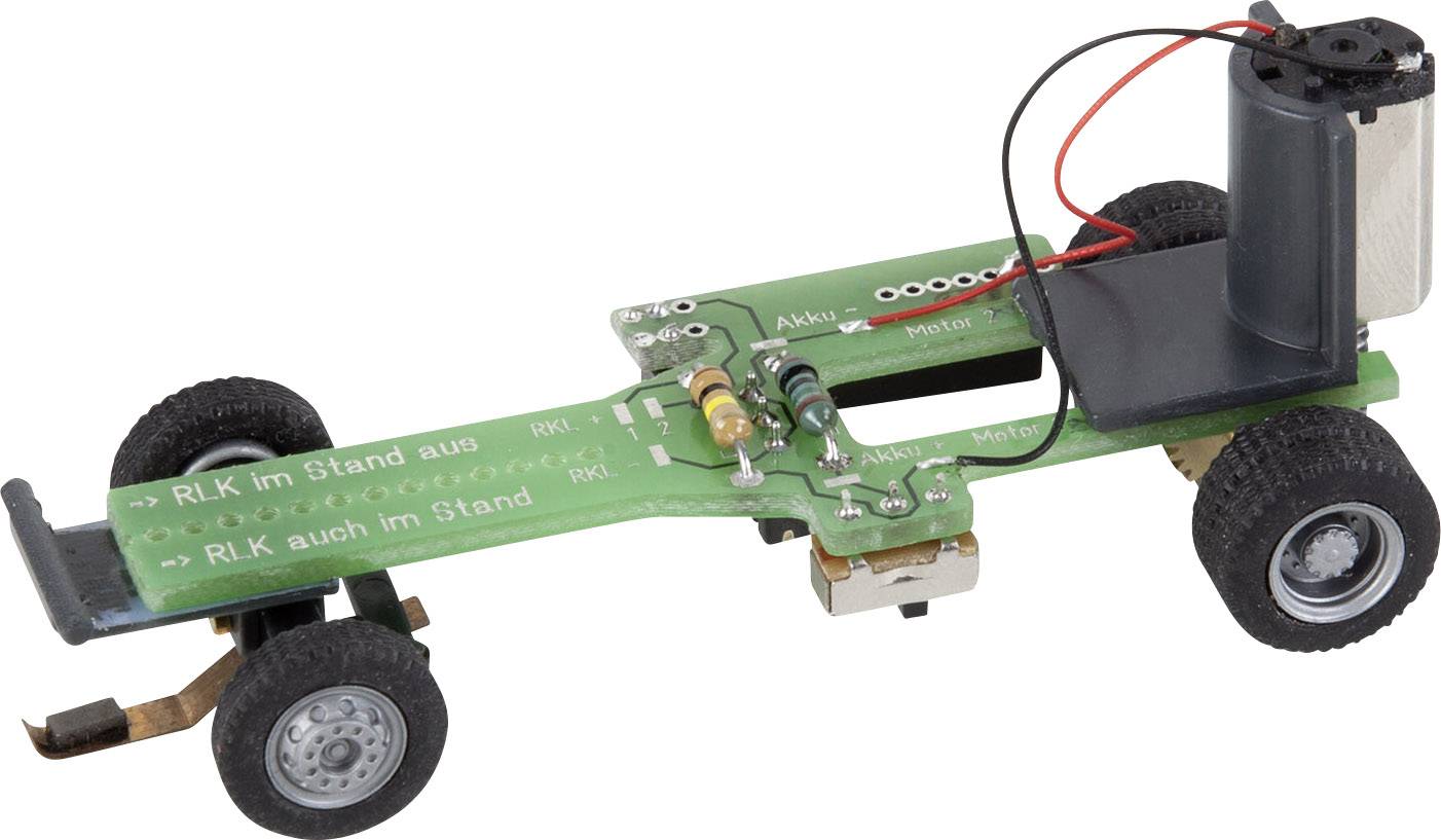 Kleines Modellfahrzeug mit grüner Leiterplatte, schwarzen Reifen und einem Batteriefach. Zeigt elektronische Komponenten und Verdrahtung.