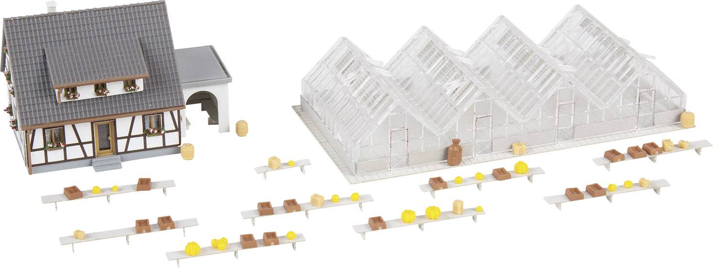 Modell eines Bauernhofs mit Fachwerkhaus, Gewächshäusern und Tischen, auf denen gelbe und braune Objekte platziert sind.