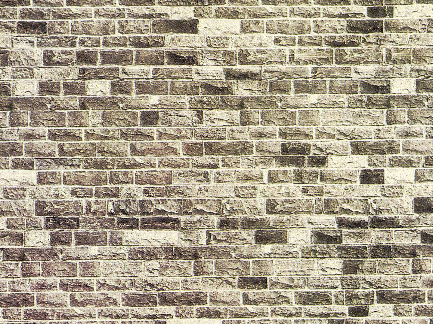 Ziegelsteinmauer mit unterschiedlichen Brauntönen und Mörtel, die eine rustikale Textur und harmonische Musterbildung zeigt.