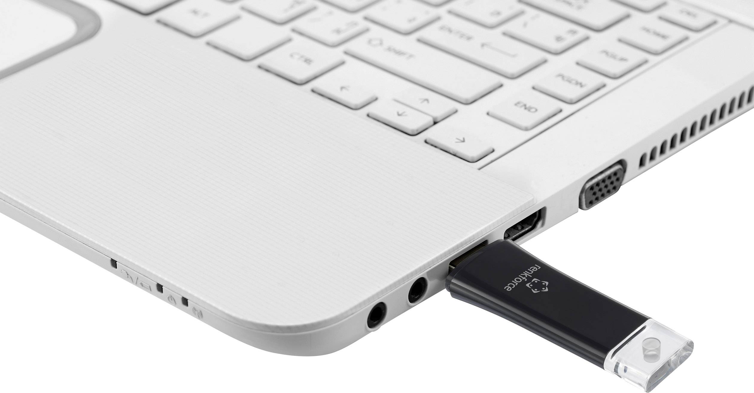 Ein USB-Stick ist an einen weißen Laptop angeschlossen. Der Laptop ist teilweise geöffnet und zeigt die Tastatur in der oberen Ecke.