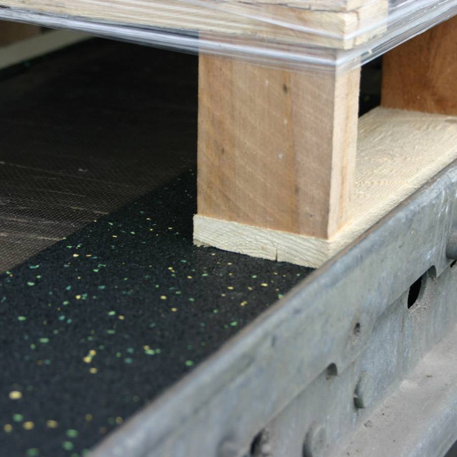 Holzpalette unter Glasplatte auf strukturiertem Metallunterbau. Zeigt handwerkliche Bauweise und Kombination von Materialien.