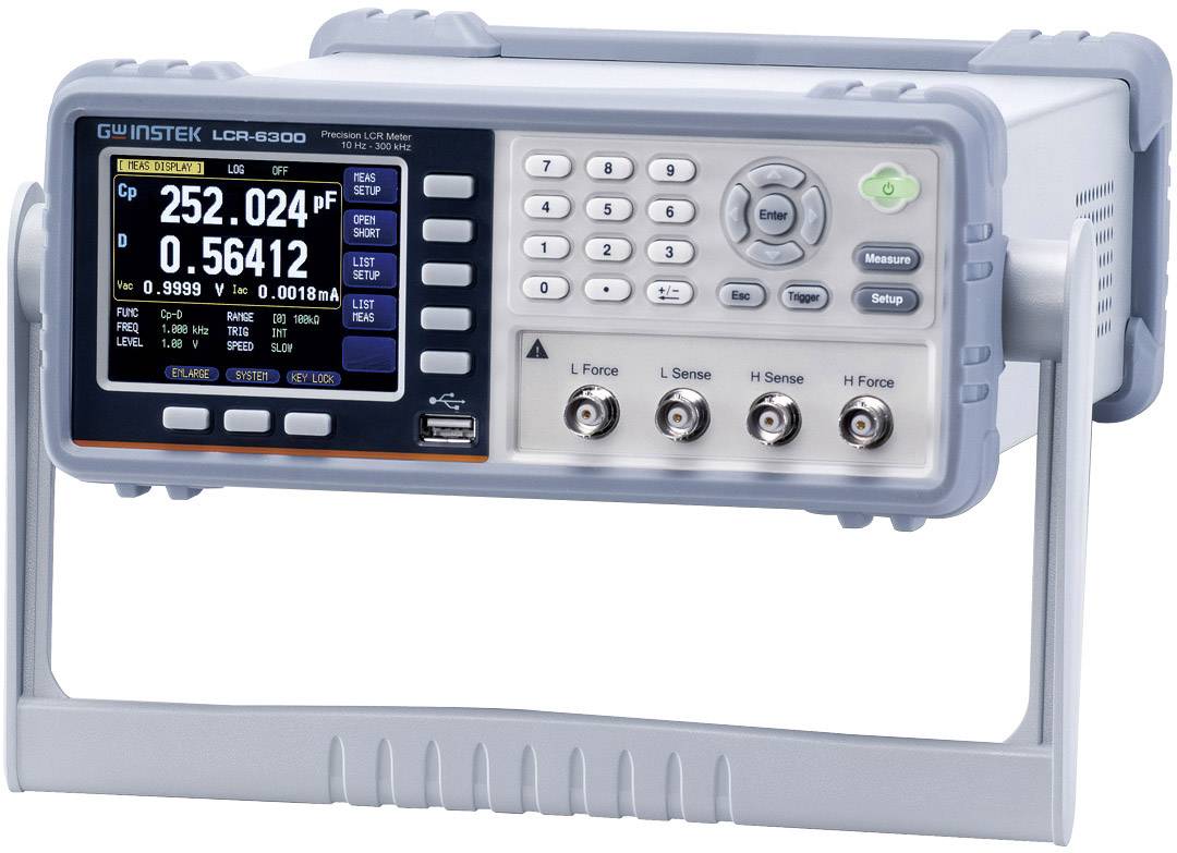 Ein LCR-Messgerät mit einem digitalen Bildschirm zeigt Kapazität, Impedanz und Verlustfaktor. Knöpfe zur Einstellung und vier Anschlussbuchsen sind sichtbar.