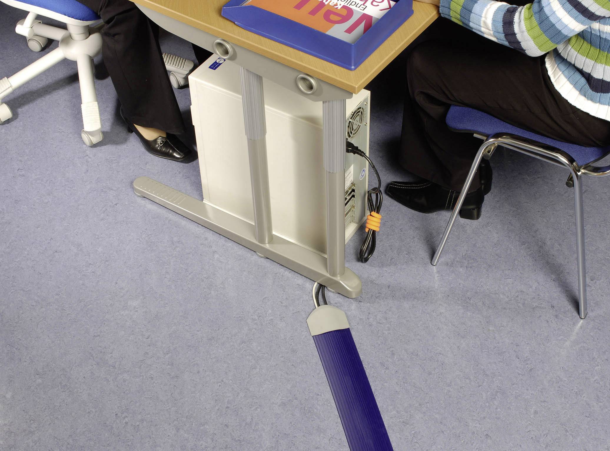 Zwei Personen sitzen an einem Schreibtisch mit einem Computer. Ein Kabelmanagementsystem hält die Kabel geordnet unter dem Tisch.