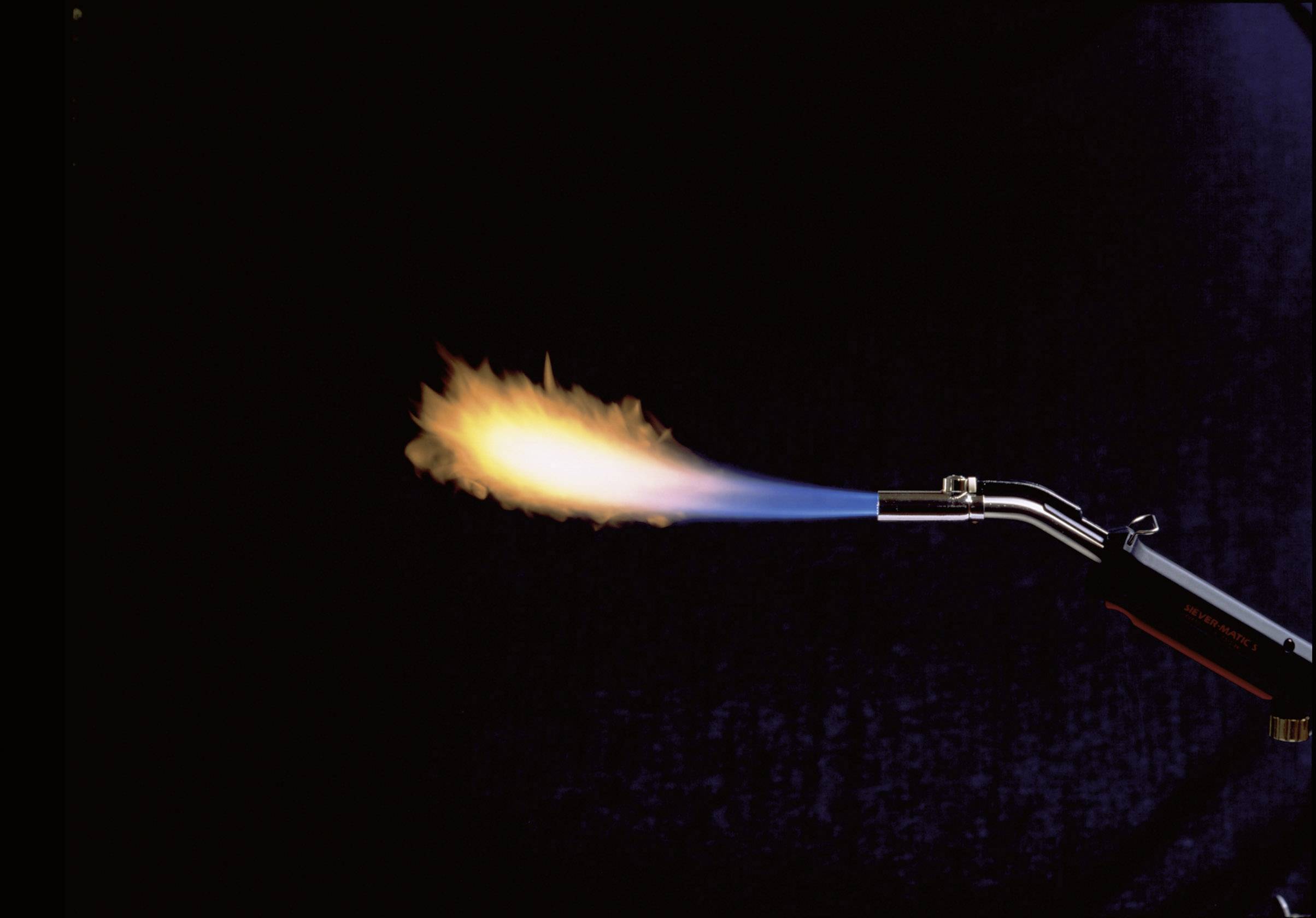 Ein Gasbrenner erzeugt eine blau-gelbe Flamme vor einem dunklen Hintergrund, geeignet für Lötarbeiten oder Heizen.