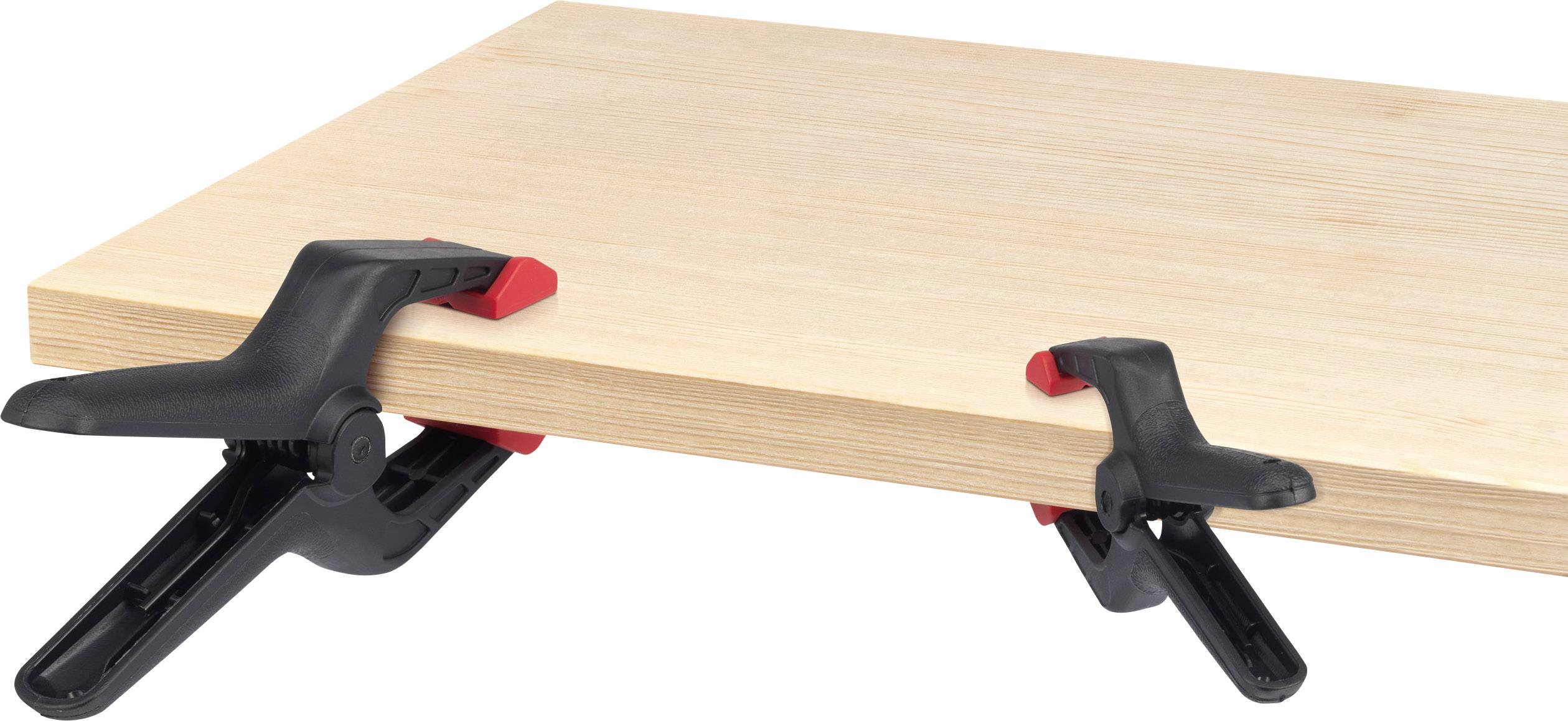 Zwei schwarze Zwingen mit roten Griffen halten eine Holzplatte.
