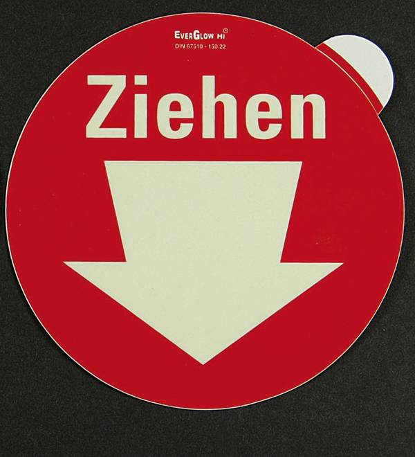 Rotes Schild mit weißem Pfeil nach unten und Text 'Ziehen', weist auf Richtung oder Handlung hin.