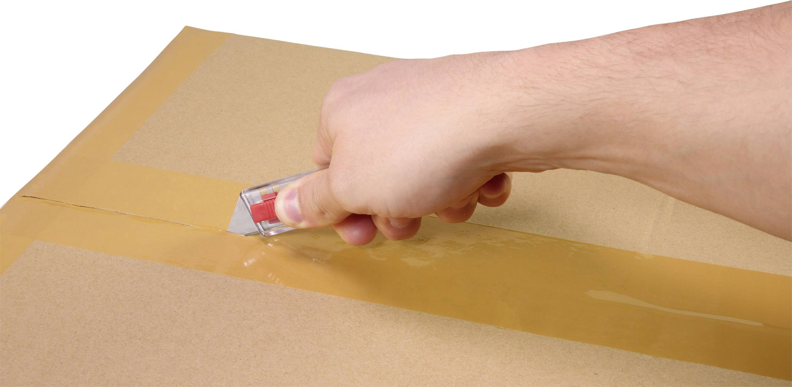 Eine Hand benutzt ein Cuttermesser, um Packband auf einem Karton zu schneiden.
