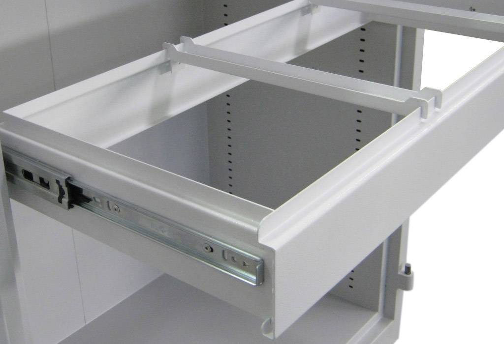 Offene, weiße Schublade in einem Schrank, zeigt interne Metallführungen und Rahmen ohne Inhalt. Mechanismus zur Ausrichtung sichtbar.