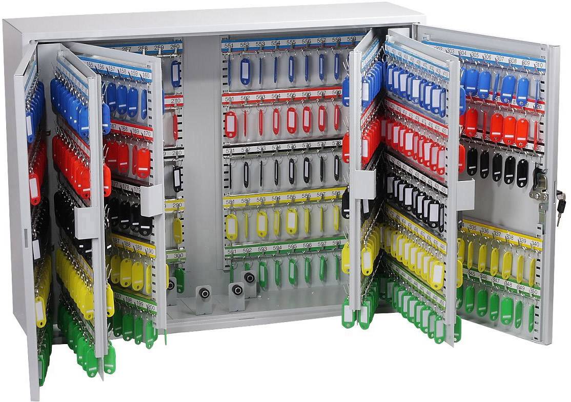 Ein offener Schlüsselschrank mit mehreren Haken und vielen farbigen Schlüsselanhängern in den Farben Rot, Blau, Gelb und Grün.