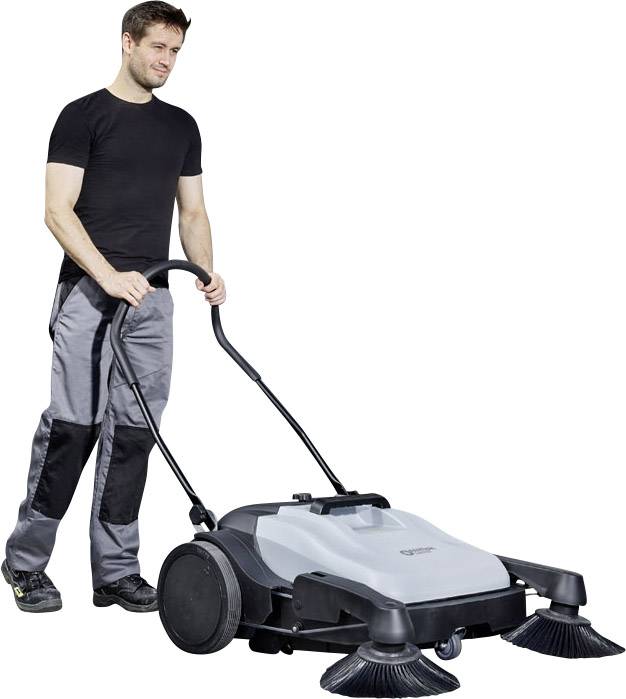 Mann in Arbeitskleidung schiebt eine große Kehrmaschine über den Boden. Die Maschine hat zwei rotierende Bürsten an der Vorderseite.