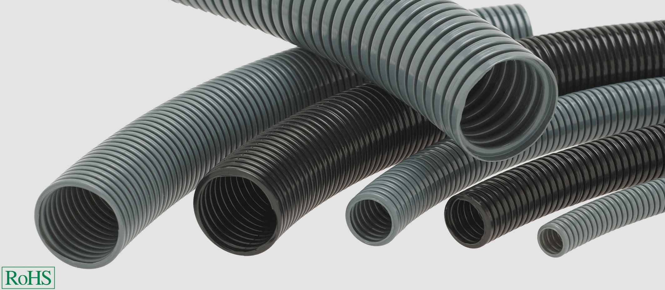 Verschiedene flexible, gerippte Schutzschläuche in Schwarz und Grau, geeignet für Kabelschutz, mit RoHS-Kennzeichnung links unten.