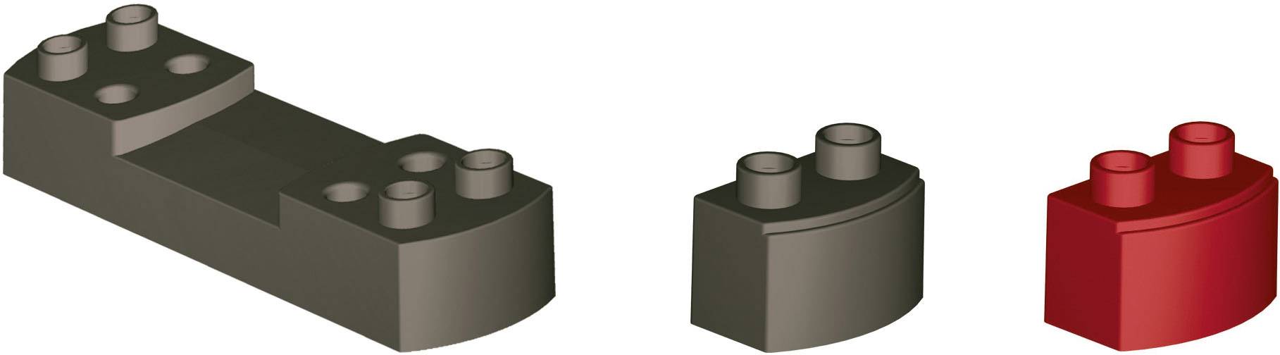 Drei unterschiedlich geformte und farbige Bausteine, von links nach rechts: große schwarze, mittlere graue, kleine rote Einheit.