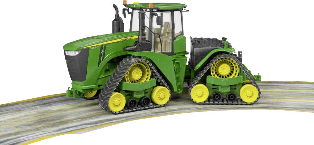 Grüner Traktor mit gelben Rädern auf einer Straße, zeigt landwirtschaftliche Maschinerie in Bewegung.