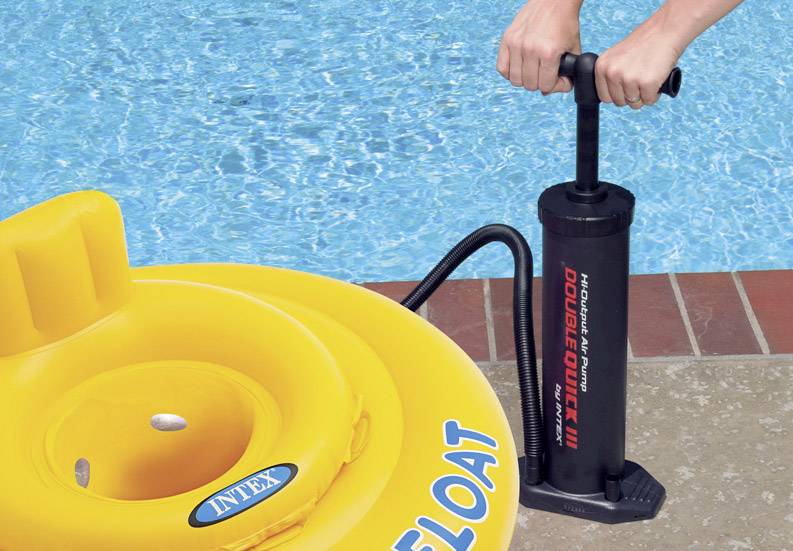 Person pumpt gelben Schwimmreifen mit Handpumpe am Rand eines Pools auf.