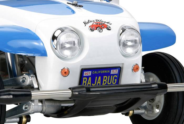 Nahaufnahme eines blauen und weißen Fahrzeugs mit einem 'Bajabug'-Kennzeichen, markanten Scheinwerfern und einem Küstenwacht-Logo.