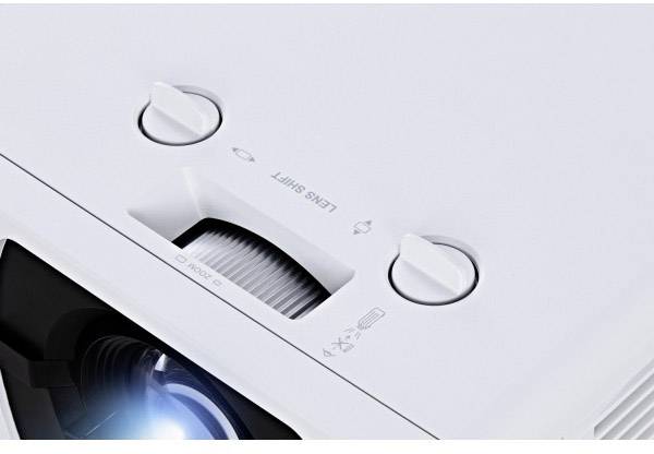 Nahaufnahme eines weißen Projektor-Objektivs mit Bedienelementen für 'Fokus' und 'Lens Shift'.