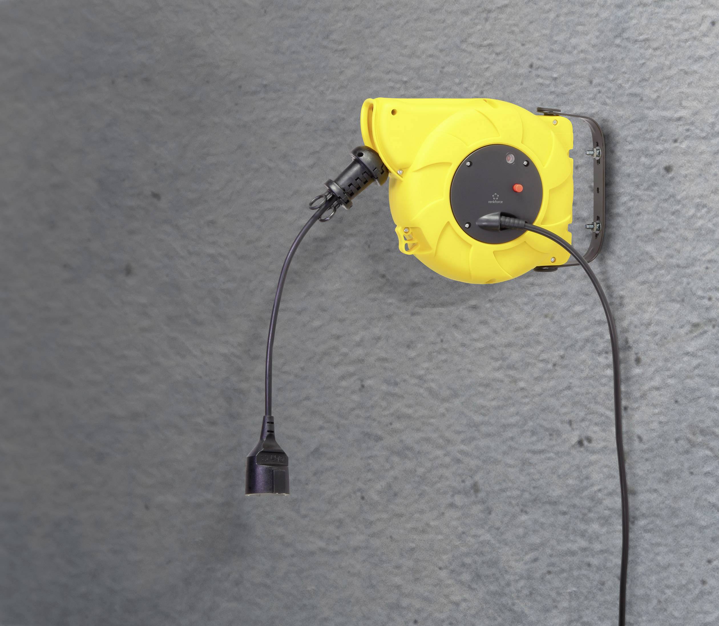 Gelbe automatische Kabeltrommel an einer grauen Wand befestigt, mit herausgezogenem schwarzem Kabel und Stecker.