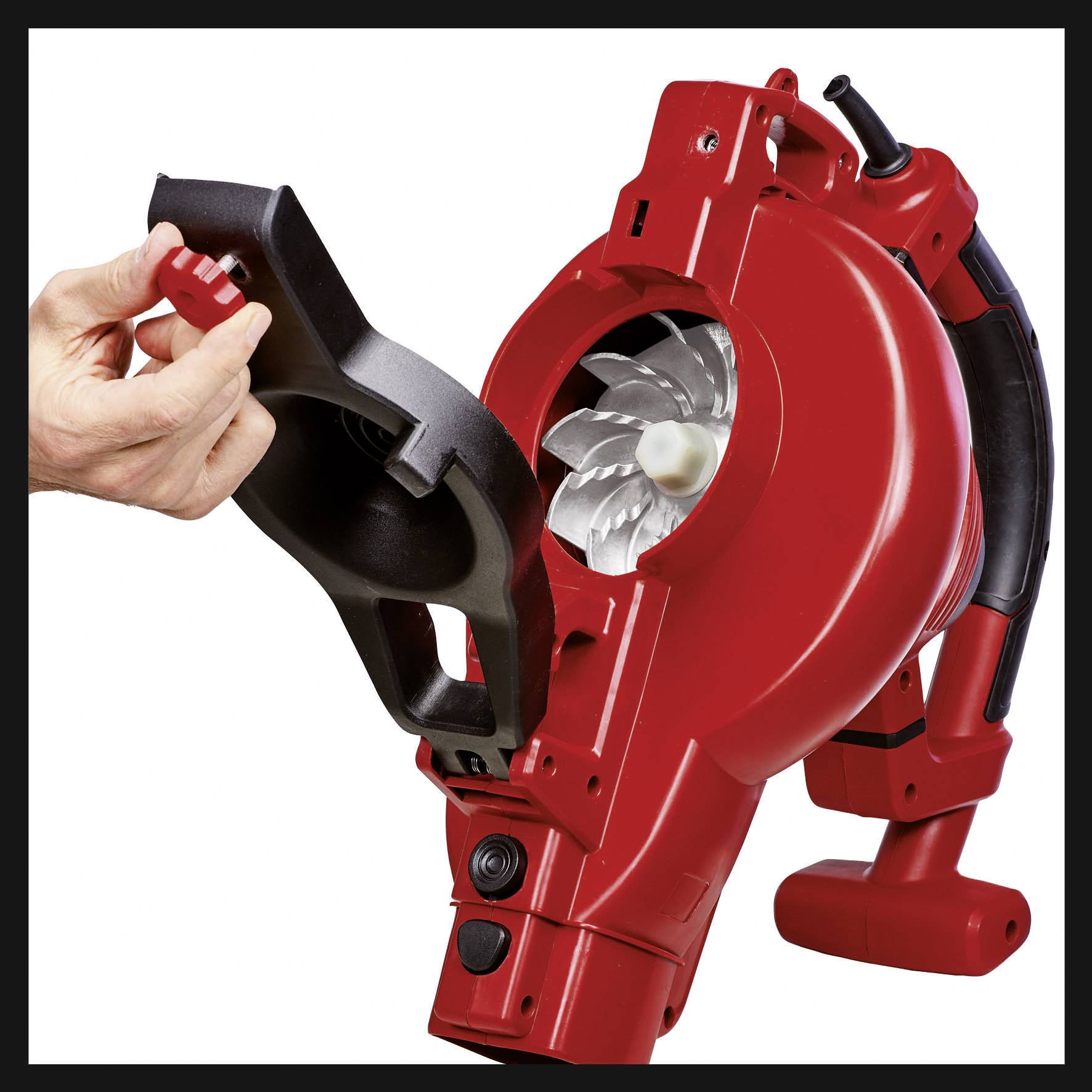 Eine rote Laubbläsermaschine mit abgenommener Abdeckung wird von einer Hand gehalten. Zeigt die Innenansicht der Turbine.