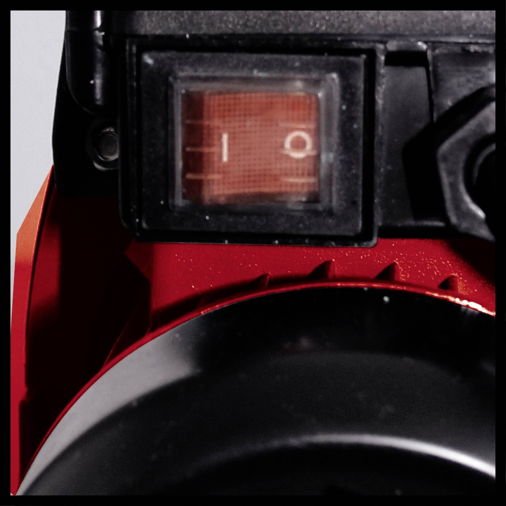 Ein Schalter mit zwei Positionen '0' und '1' auf einem roten Gerät, möglicherweise ein elektronisches oder technisches Gerät.