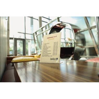 Speisekarte auf einem Tisch in einer modernen Lounge, zeigt Preise für verschiedene Kaffeespezialitäten, Fenster im Hintergrund.