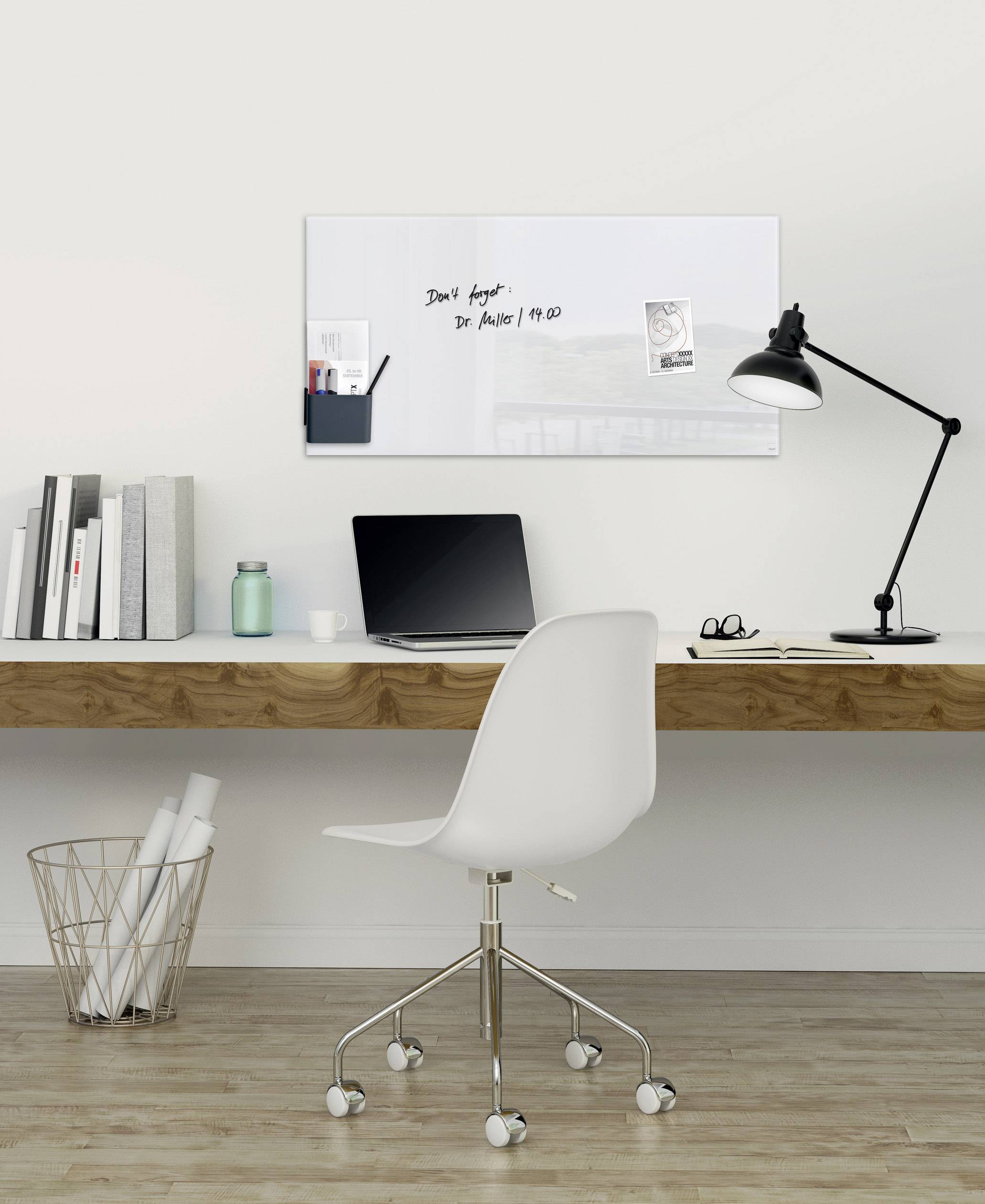 Ein minimalistischer Arbeitsplatz mit einem weißen Schreibtisch, einem Laptop, einer Lampe, Büchern und einem Whiteboard mit Notizen.
