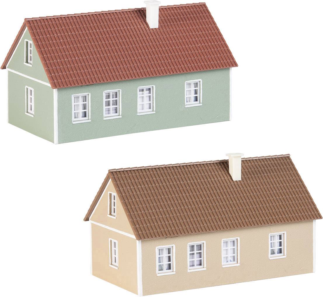 Zwei Miniaturhäuser mit roten Schrägdächern; das obere ist grün, das untere beige. Beide haben weiße Fensterrahmen und Kamine.