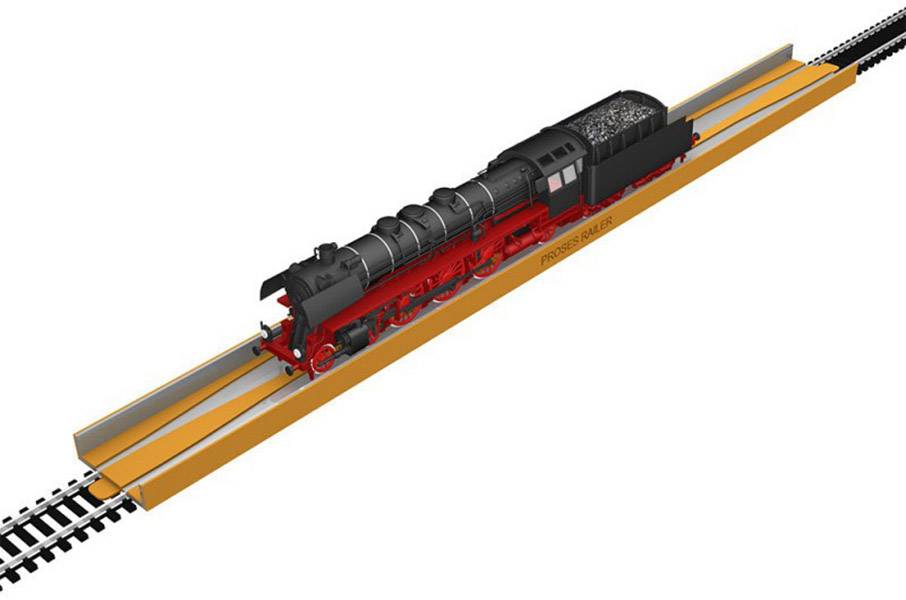 Eine schwarze Dampflokomotive auf einem orangen Reparaturständer. Sie ist auf einem geraden Gleisabschnitt positioniert.