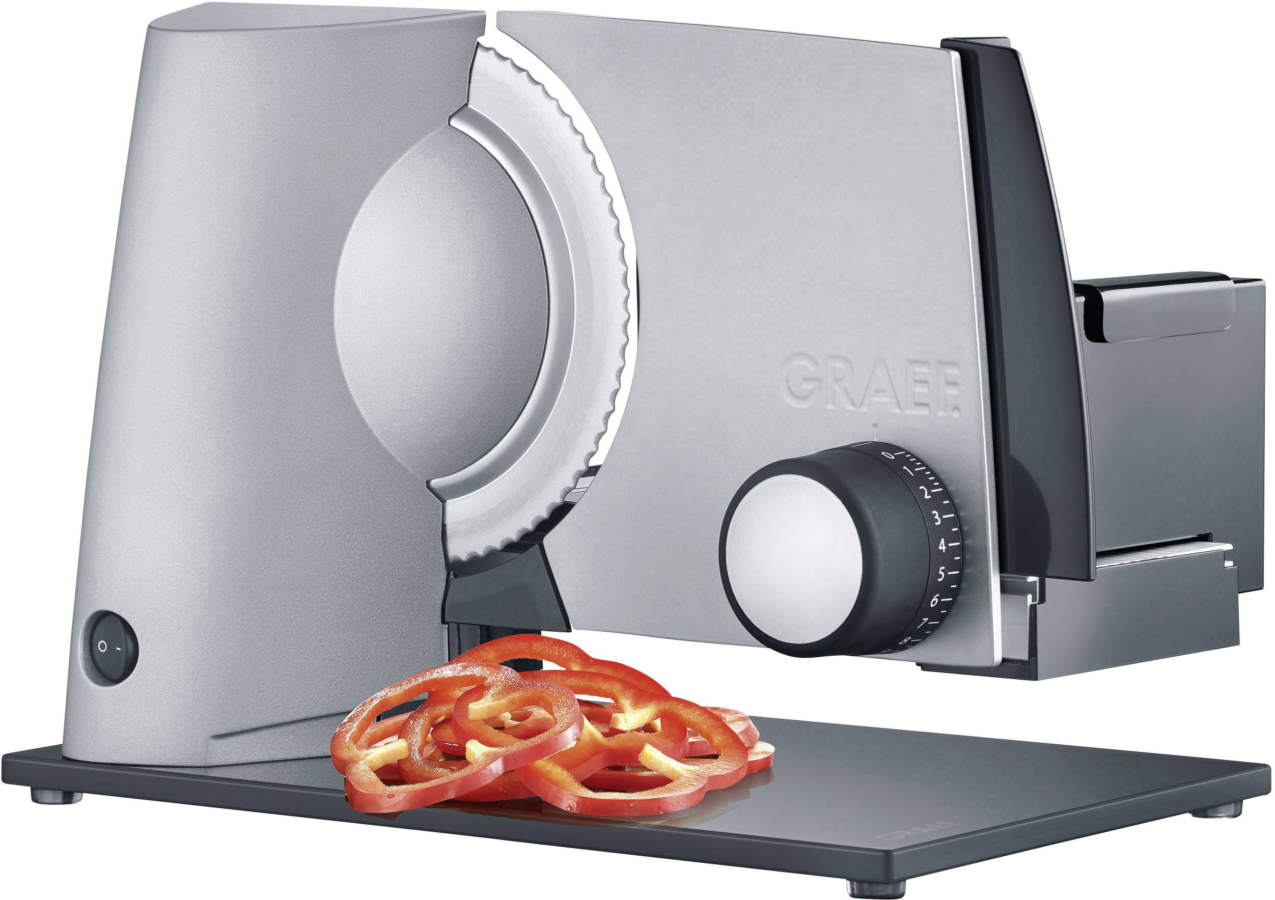 Elektrischer Allesschneider in Silber mit geriffeltem Messer; geschnittene Tomatenscheiben liegen davor.
