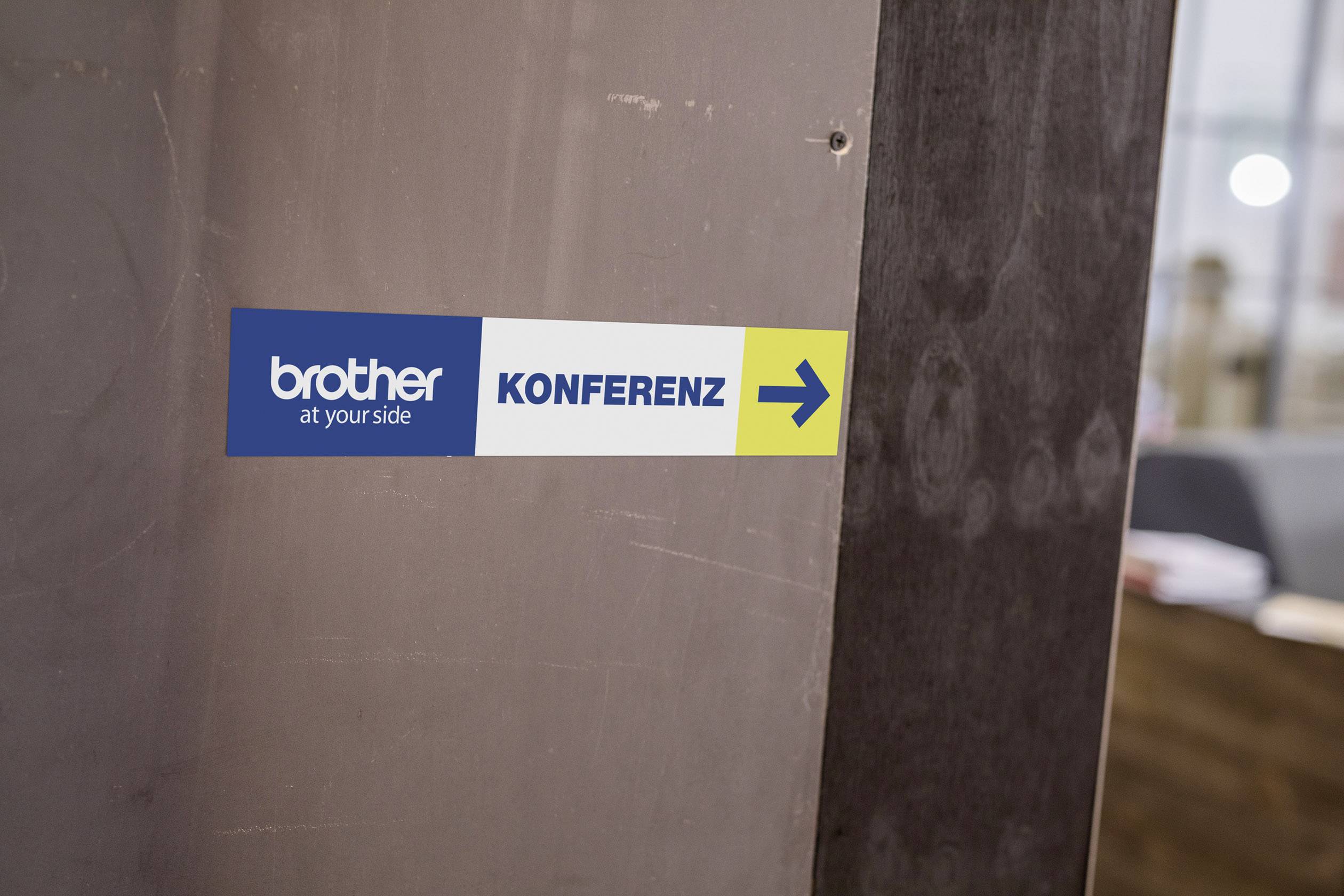 Schild mit dem Text: brother at your side KONFERENZ, Pfeil nach rechts, weist den Weg zur Konferenz.