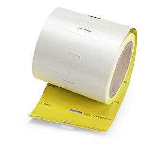 Weiße Etikettenrollen mit gelben Trennblättern für industrielle Kennzeichnung.