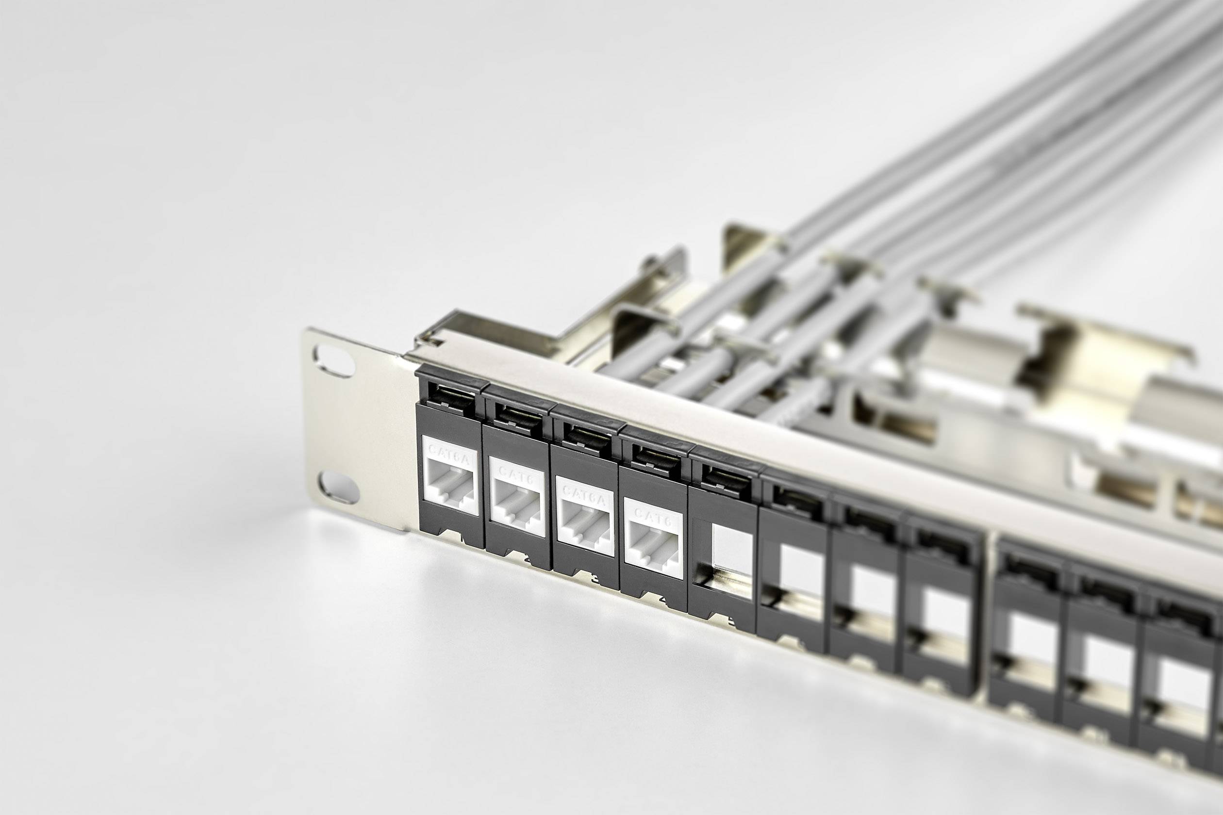 Ein Netzwerk-Patchpanel mit mehreren Ethernet-Anschlüssen und Kabeln, montiert in einem Server-Rack, zeigt die Verkabelungsstruktur.