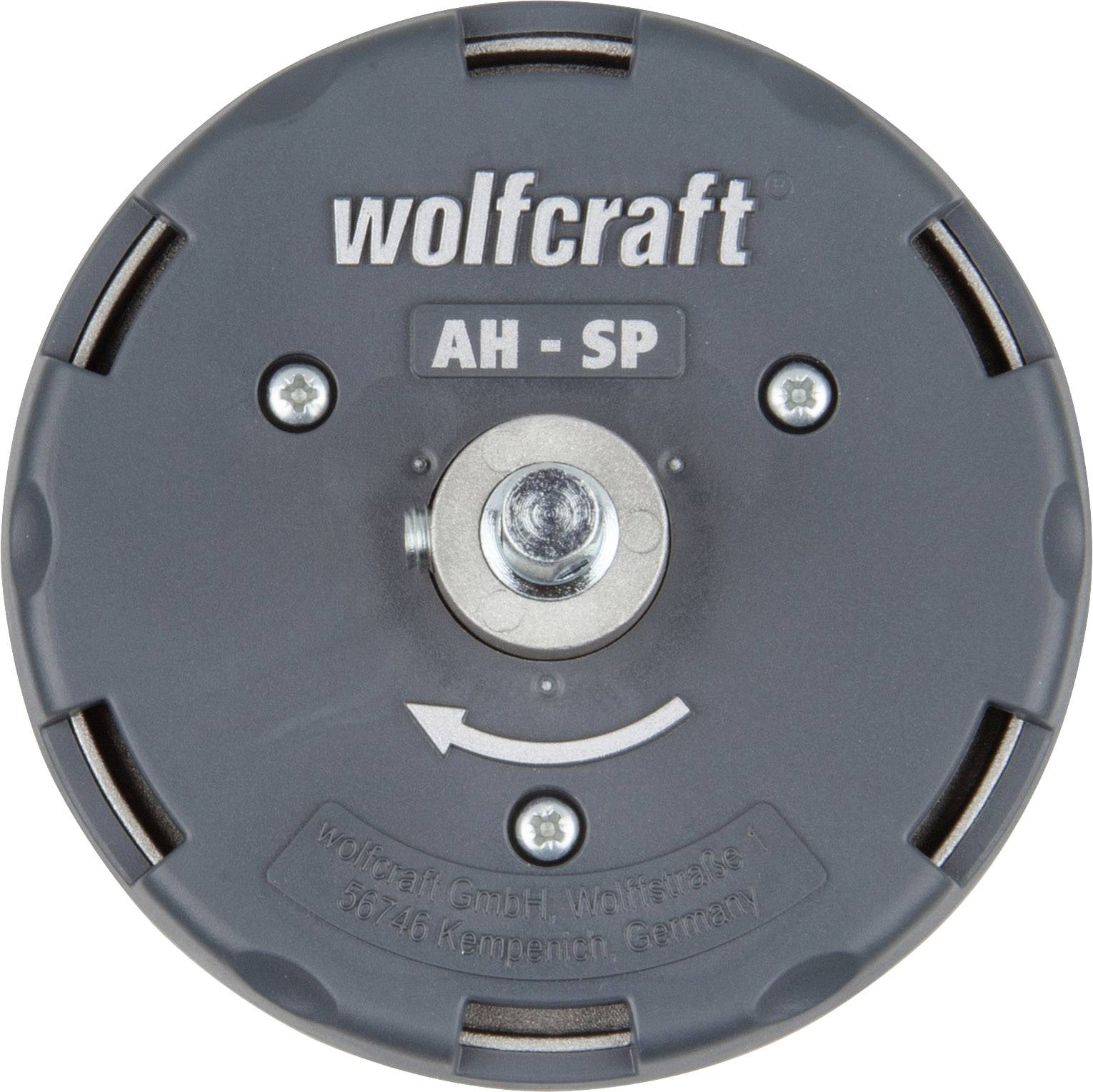 Ein runder grauer Adapter mit der Aufschrift 'wolfcraft AH-SP', zentraler Schraube und einem Pfeil. Herstellername und Adresse unten.