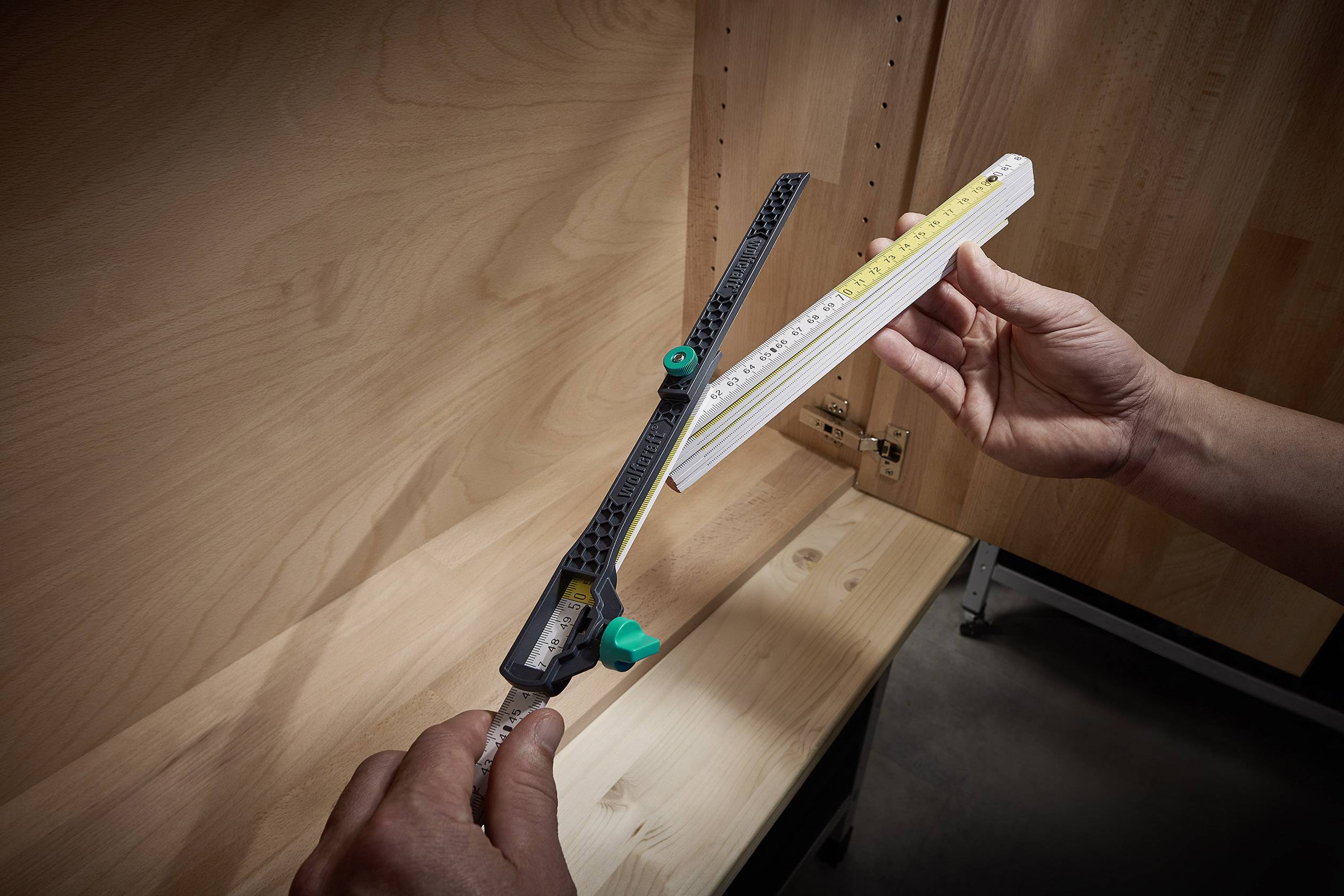 Eine Person misst mit zwei verschiedenen Werkzeugen die Innenabmessungen eines Holzschranks: ein Lineal und eine Messlehre.